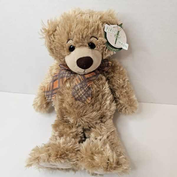 Plush teddy bear with a plaid bow tie and hanging tag