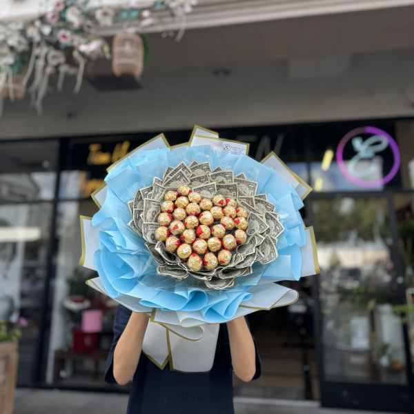 Bouquet of dollar bills and chocolate candies wrapped in blue paper