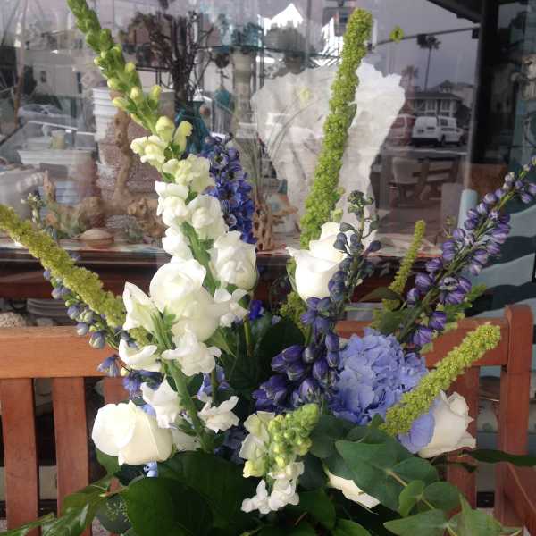 Tall bouquet of white and purple flowers in a glass vase