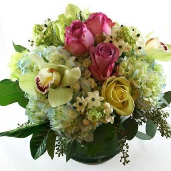 Mixed bouquet of roses, hydrangeas, and orchids in a vase