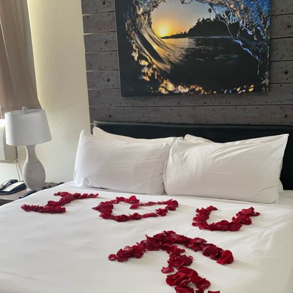 Bed decorated with red rose petals spelling "I LOVE U"