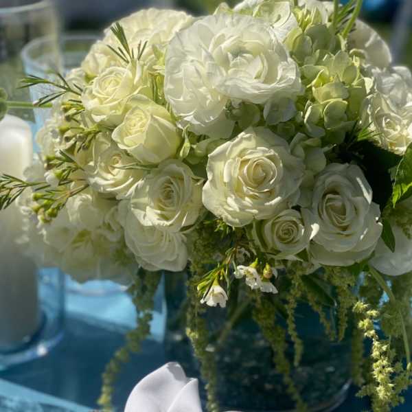White rose and ranunculus bouquet with green accents and a gray ribbon