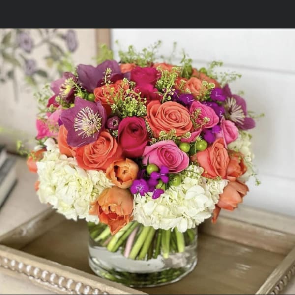 Mixed pink, coral, and purple bouquet in a clear glass vase