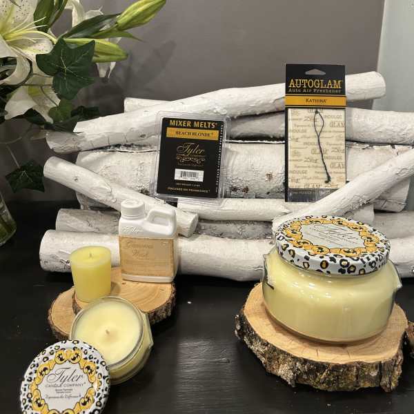 Candles and fragrance products arranged with a white lily bouquet