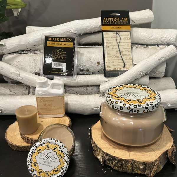 Candle and fragrance gift items arranged on wood slices with white birch logs