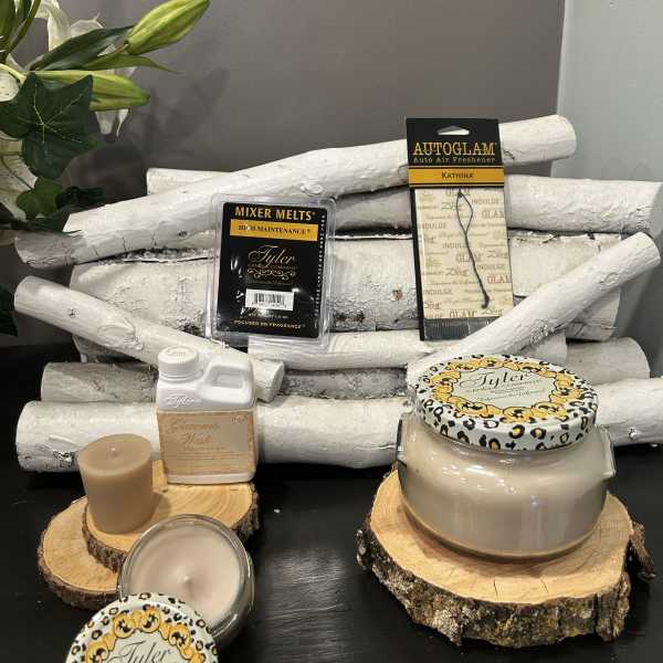 Candles and fragrance products arranged on wood slices with white branches