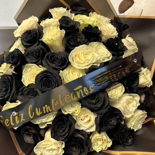Bouquet of black and cream roses wrapped in black paper