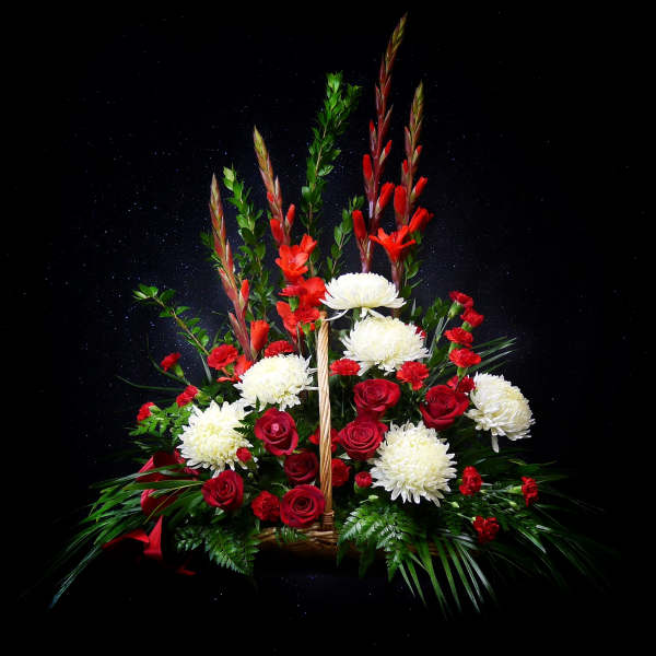 Red and white floral arrangement in a basket with tall stems