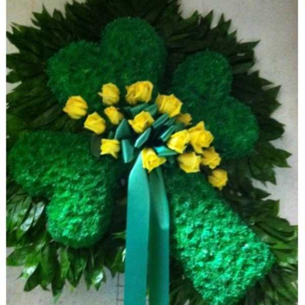 Green floral wreath with yellow roses and a teal ribbon