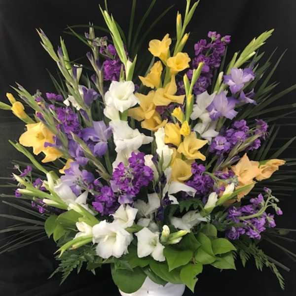 Yellow, white, and purple flowers in a white vase
