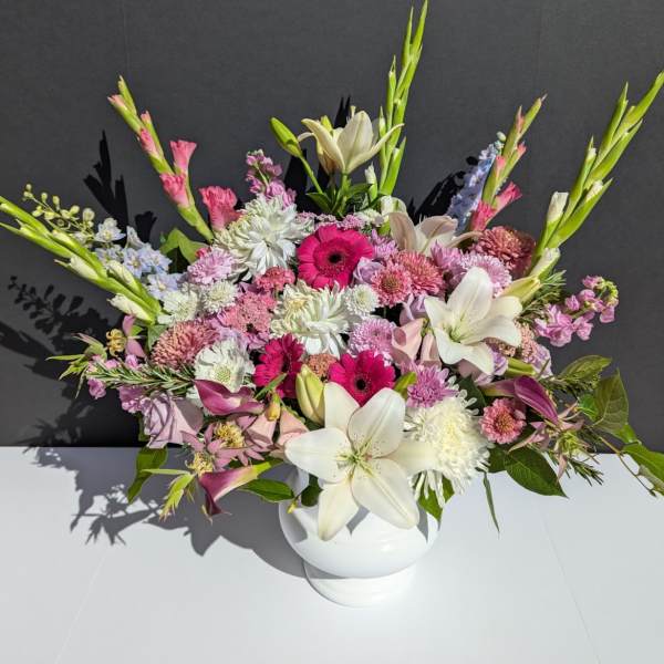 Mixed pink and white floral arrangement in a white vase