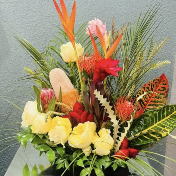Tropical bouquet with yellow roses and orange bird-of-paradise flowers