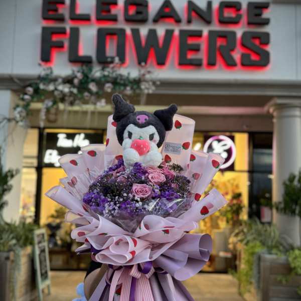 Bouquet of pink and purple flowers with a plush character topper