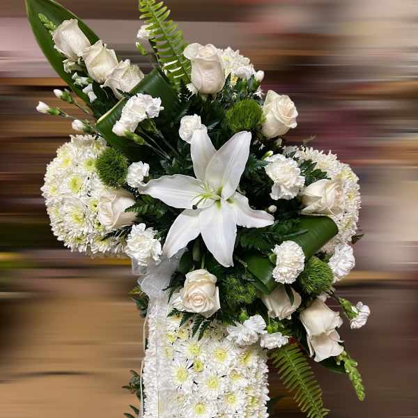 Tall white sympathy spray with roses, lilies, carnations, and cushion of chrysanthemums accented with ribbon