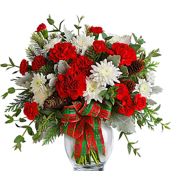 Red carnations and white chrysanthemums in a glass vase with a plaid ribbon