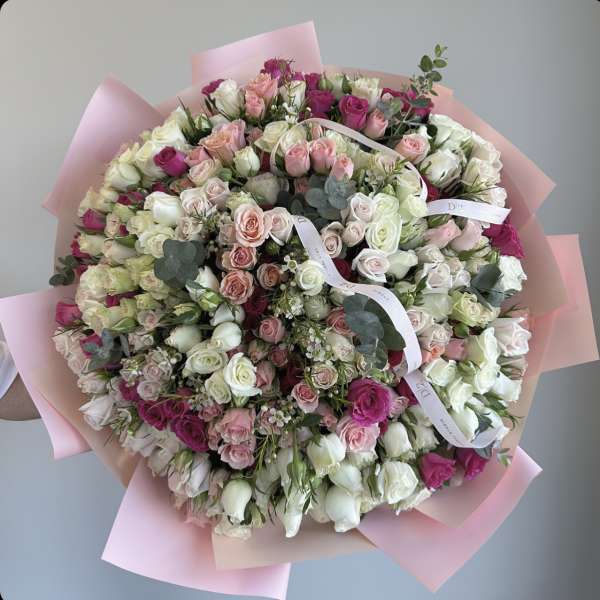 Large bouquet of pink, white, and magenta roses wrapped in pink paper