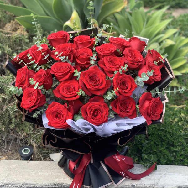Bouquet of red roses with eucalyptus in black wrapping