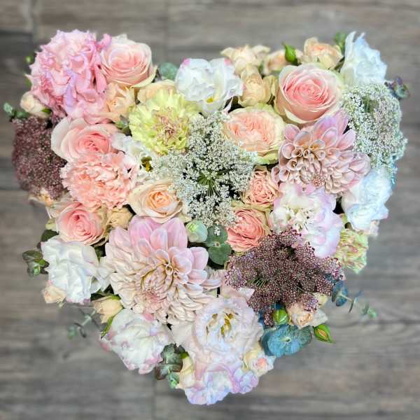 Heart-shaped bouquet of pastel roses, dahlias, and white filler flowers