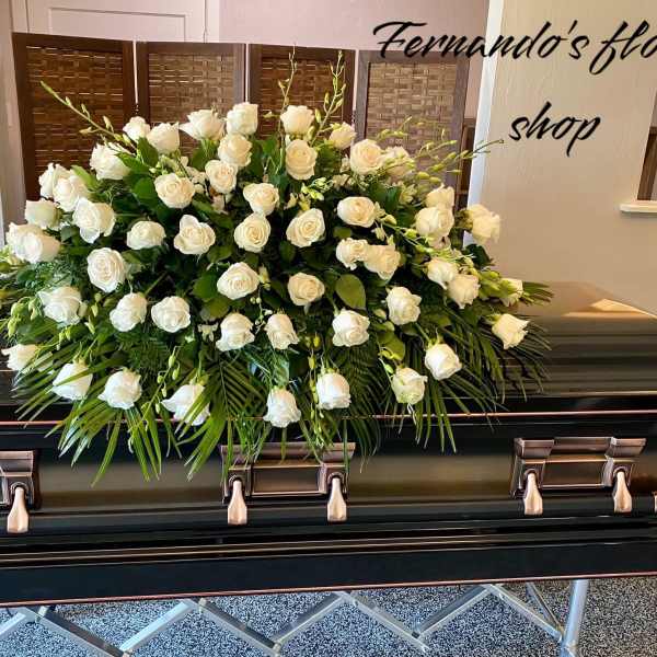 Large white rose casket spray arranged on a dark casket