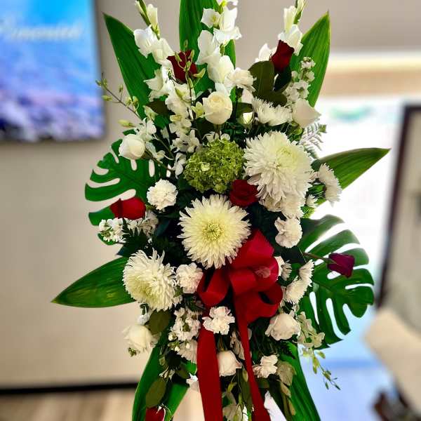 Tall white and red standing spray with large mums and roses on an easel