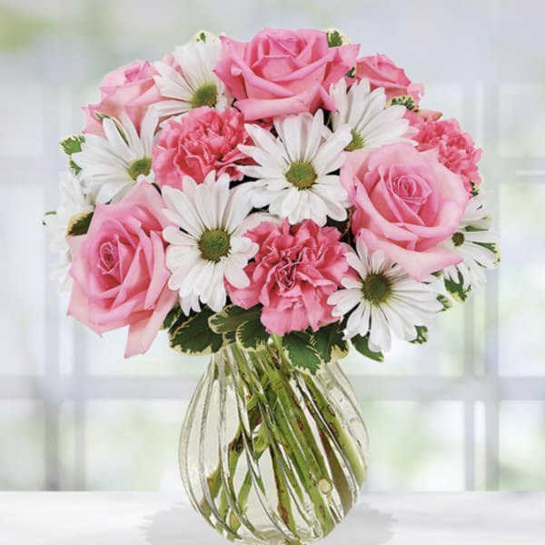 Pink roses and white daisies in a clear glass vase