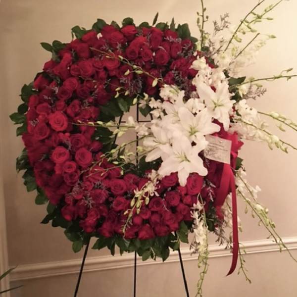 Large red rose wreath with white lilies on a stand