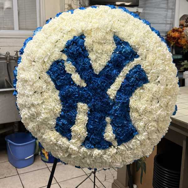 Round floral tribute with a blue and white monogram design