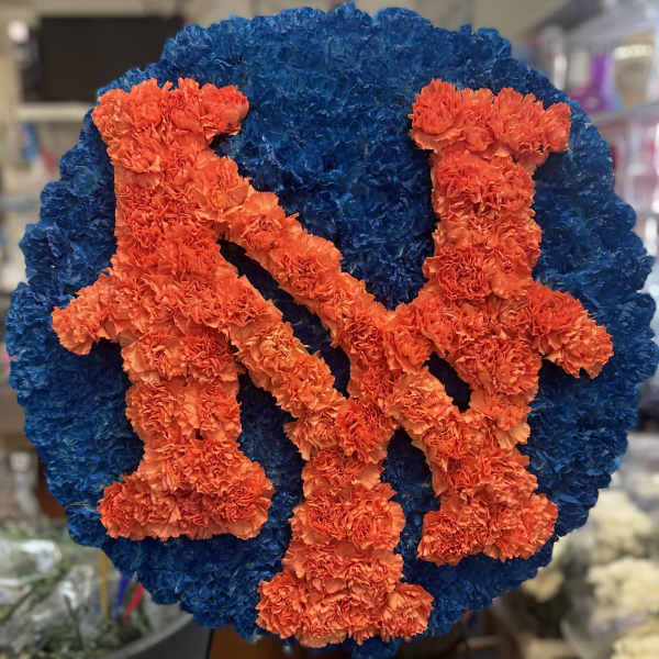 Blue and orange floral tribute with two figures on a round base