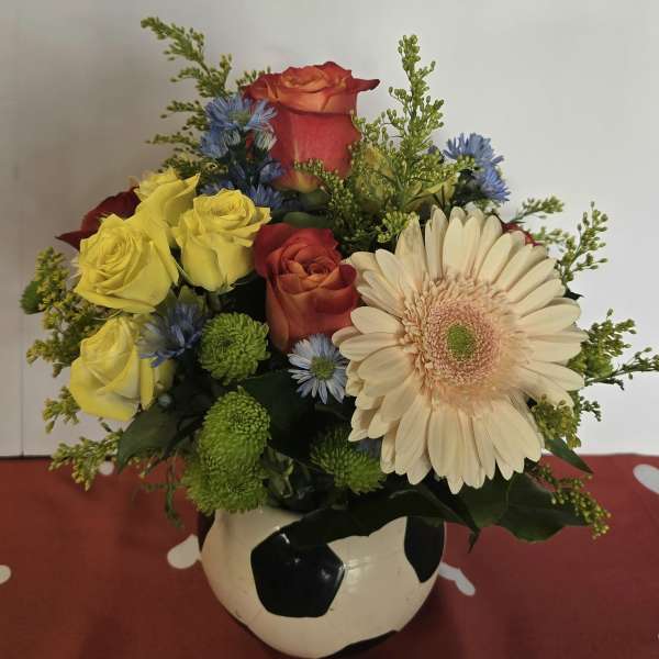 Mixed bouquet in a soccer ball vase with roses and a gerbera daisy