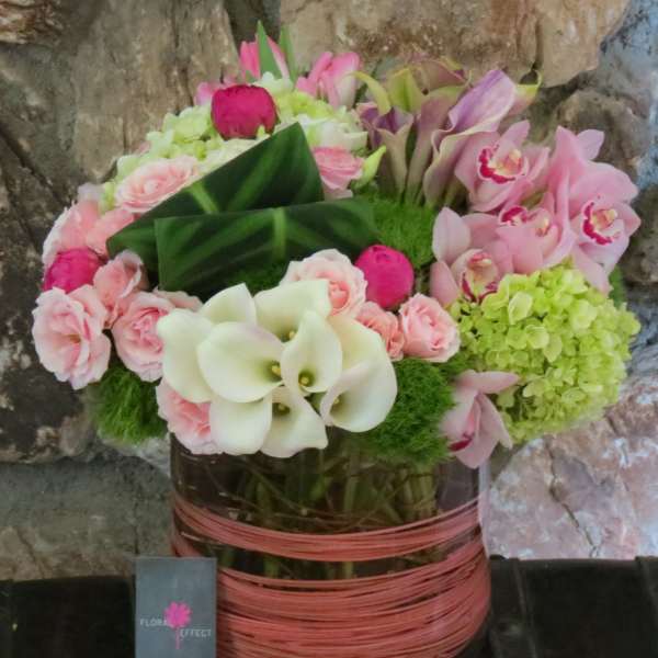 Pink and white floral arrangement in a wrapped vase