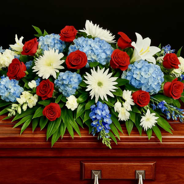 Red, white, and blue casket spray on a polished wooden casket