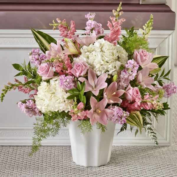 Large pink and white arrangement with lilies, roses, and hydrangeas in a white vase