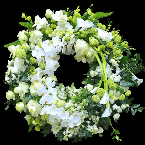 Large white and green floral wreath with orchids, roses, calla lilies, and pompom blooms