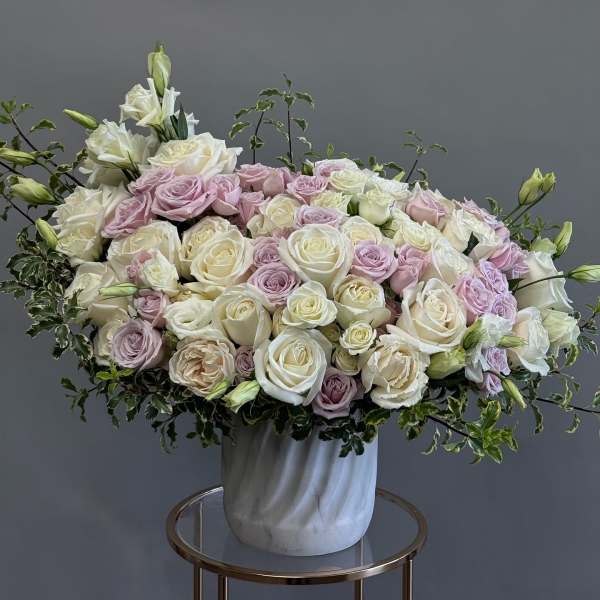 Large bouquet of white and pale pink roses in a white vase