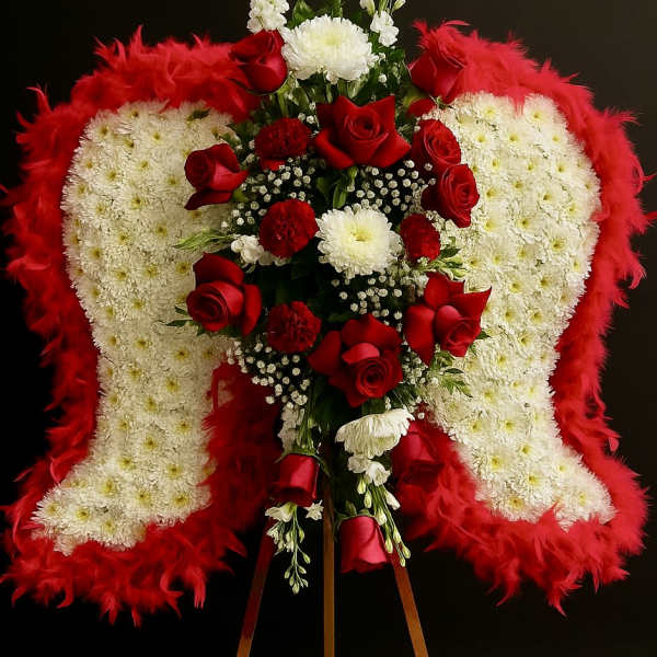 Standing sympathy arrangement of white angel wings with red roses on a wooden easel