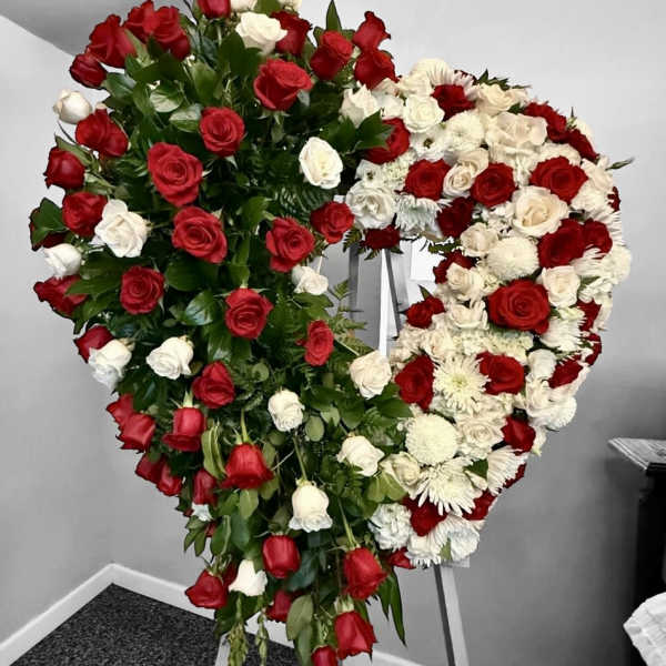 Heart-shaped standing spray of red and white roses on an easel