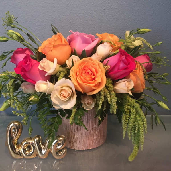 Mixed rose bouquet in a pink vase with a gold "love" decoration