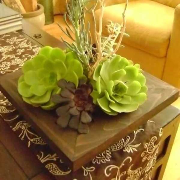Succulent arrangement in a square planter on a table