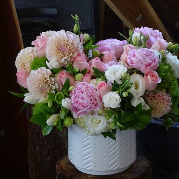 Pink and white mixed flower arrangement in a white vase
