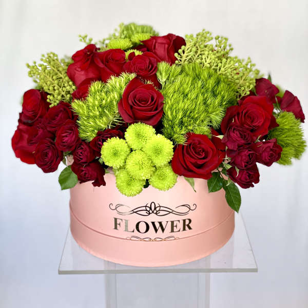 Red roses and lime-green pompons in a pink hat box