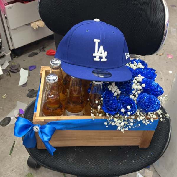 Gift box with beer bottles, blue roses, and an LA cap on a chair