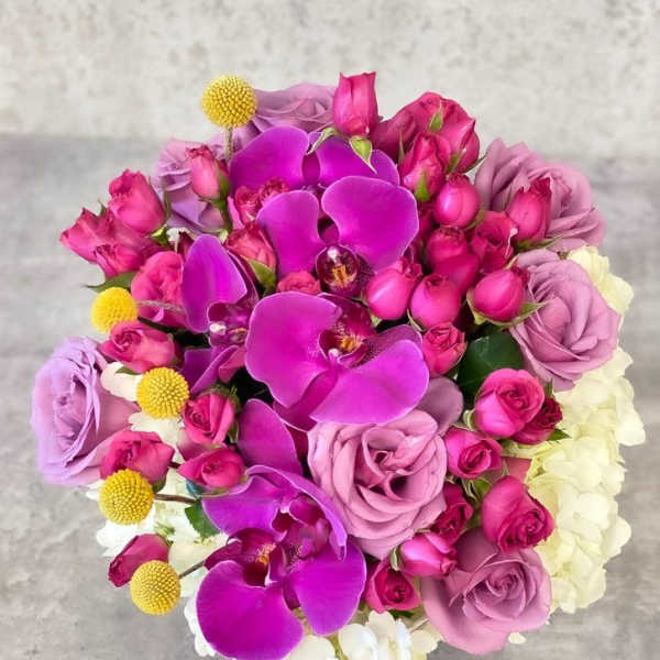 Bouquet of pink roses and purple orchids with white blooms