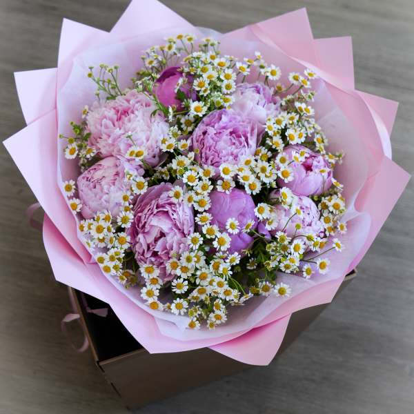 Pink peony bouquet with small white daisies in pink wrapping