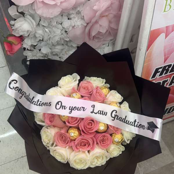 Pink and white rose bouquet with chocolates and a graduation ribbon