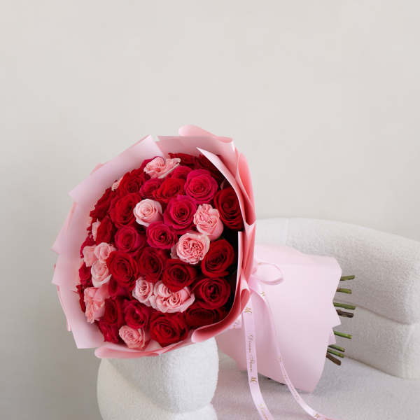 Bouquet of red and pink roses wrapped in pale pink paper