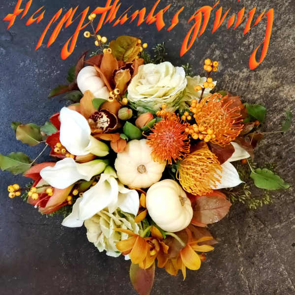 Autumn bouquet with white calla lilies, orange blooms, and small pumpkins