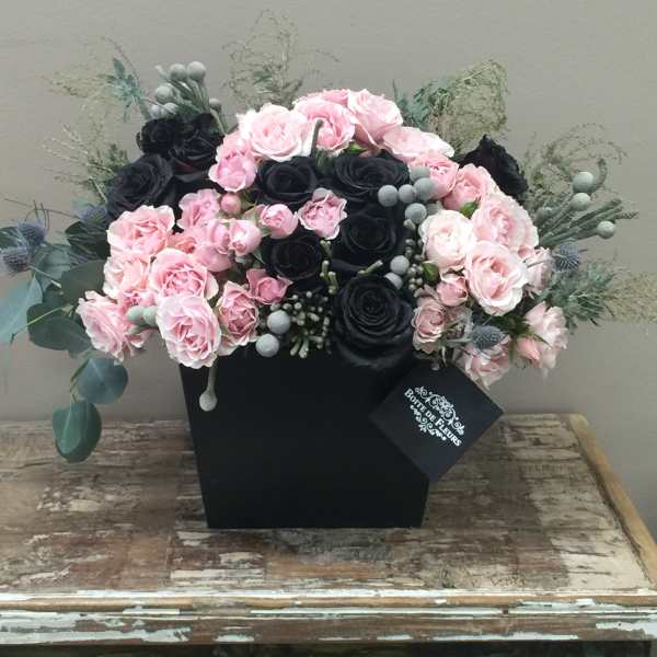 Pink and black rose arrangement in a black box