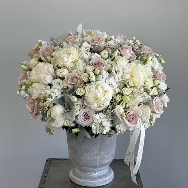 Blush and white rose bouquet in a gray pedestal vase