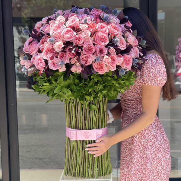 Large bouquet of pink roses with dark purple accents