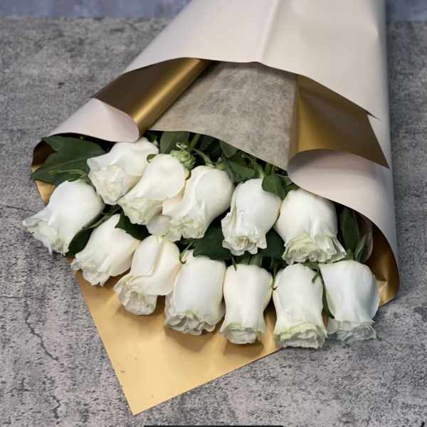 Bouquet of white roses wrapped in cream and gold paper